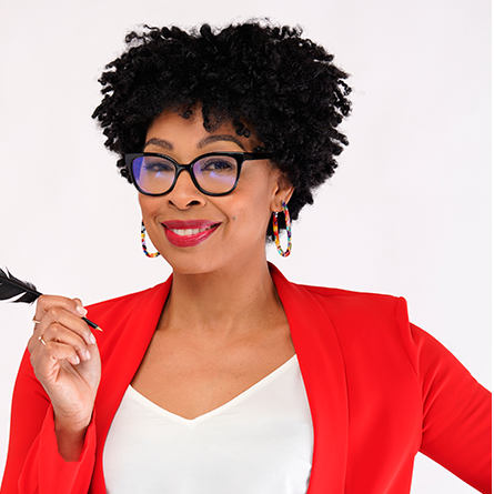 A woman with mid-length curly hair and glasses holding a feather pen